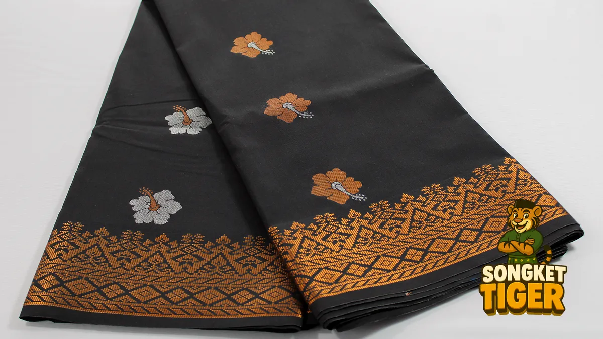 Songket fabric folded showing gold motif detail across the surface
